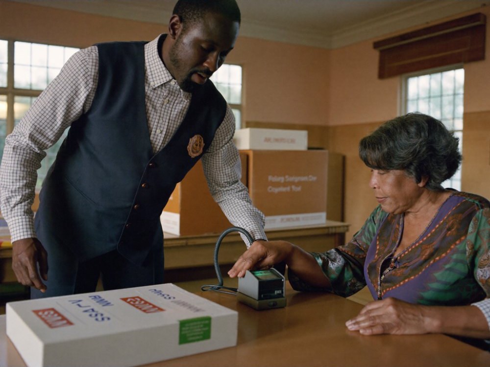 An election official verifying a voter's fingerprint at a polling station